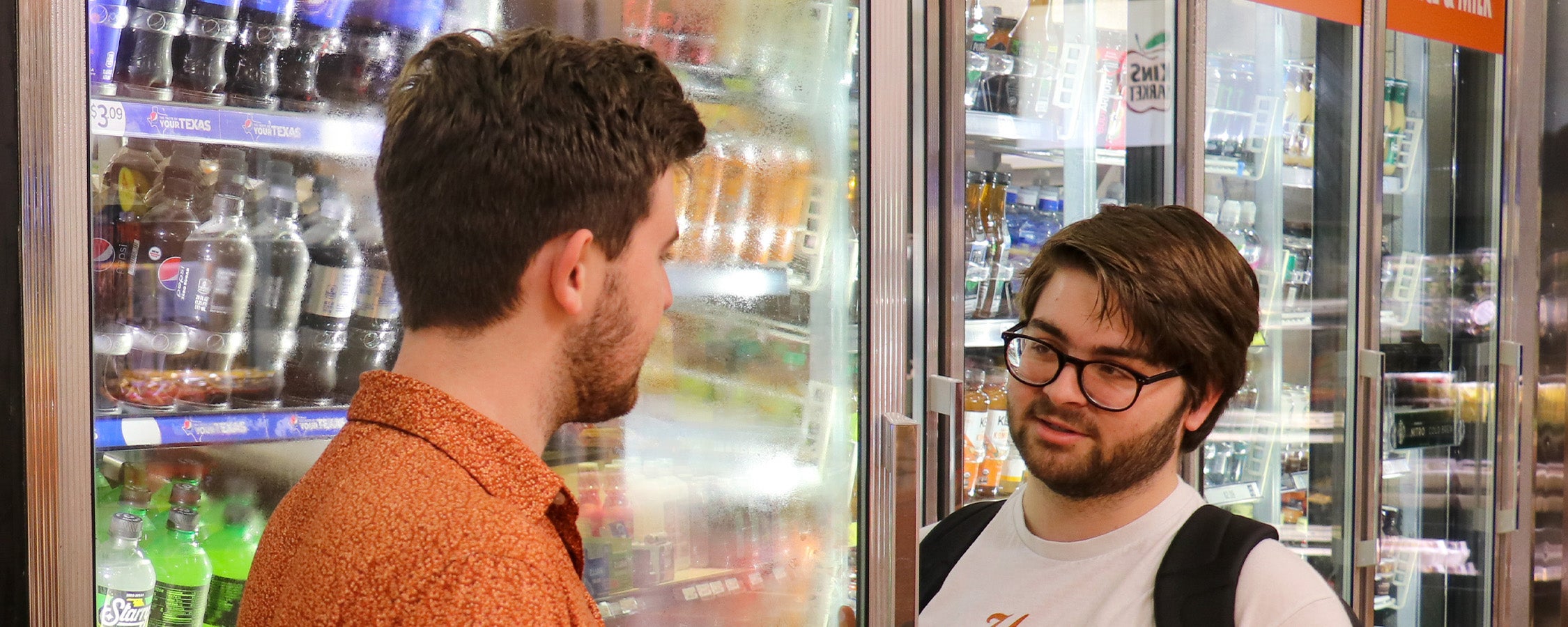 Two students talking to each other at Kin’s Market, the convenience store inside Kinsolving Residence Hall.