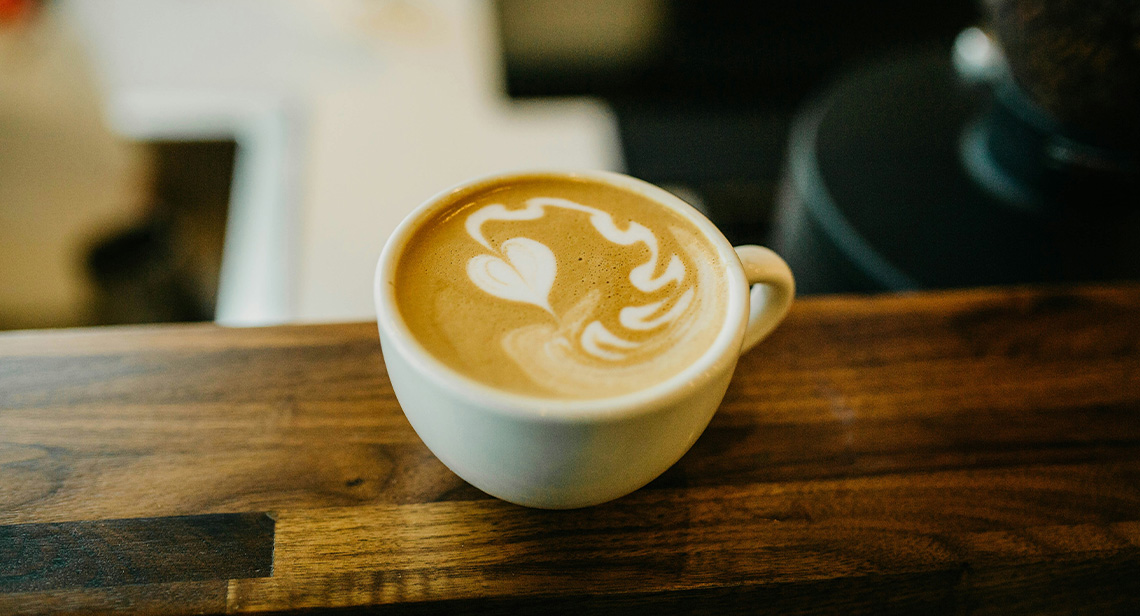 A mug displaying latte art on a table. 