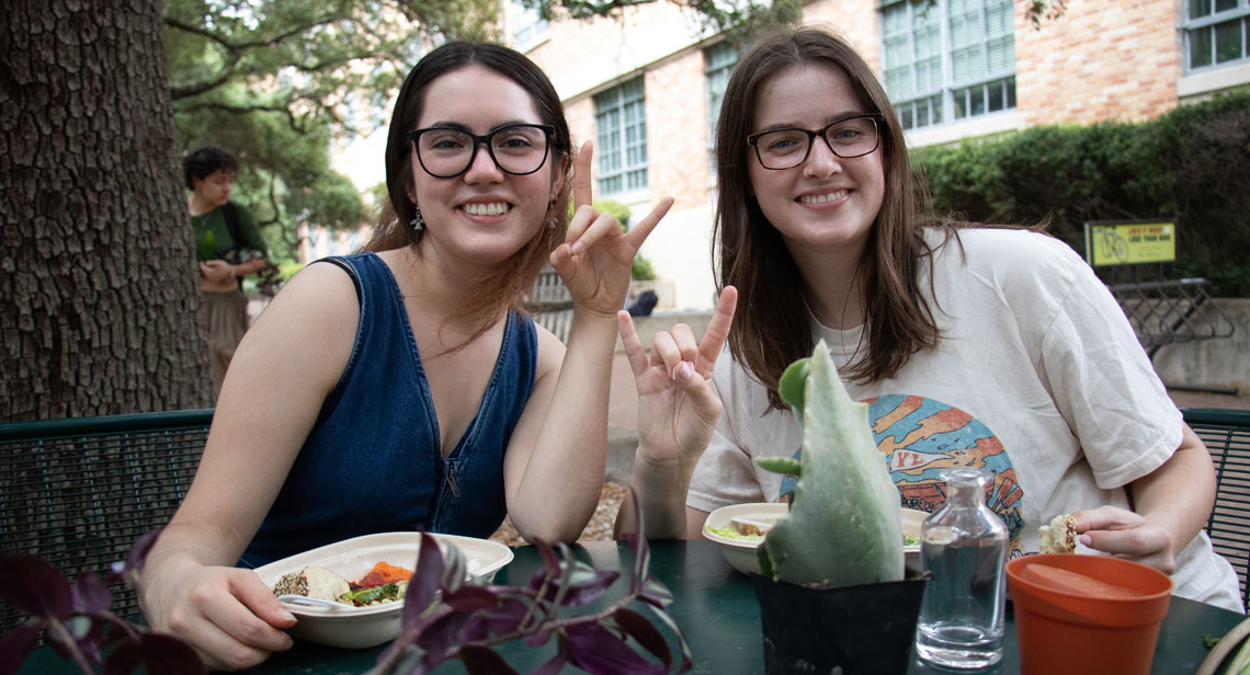 Two UT students pose together at the Forty Acres Earth Day Fair event. 