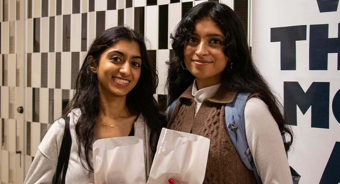 Two UT students pose together at the Cookies and Caffeine event