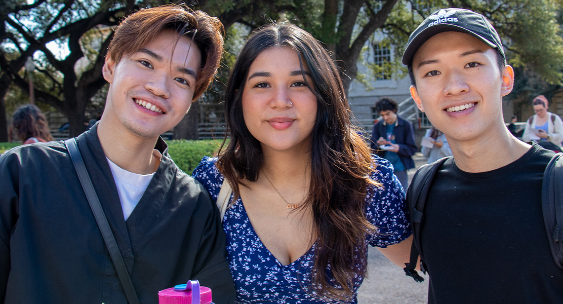 Three UT students pose together