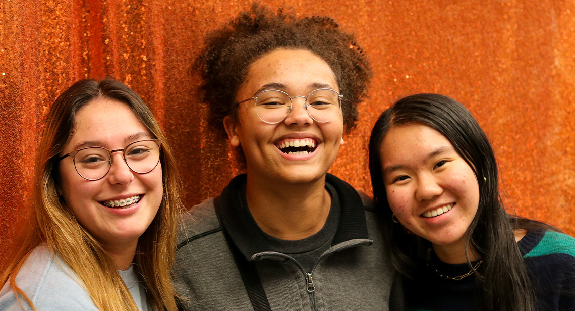 Three UT students pose together at the Friendsgiving Dinner event