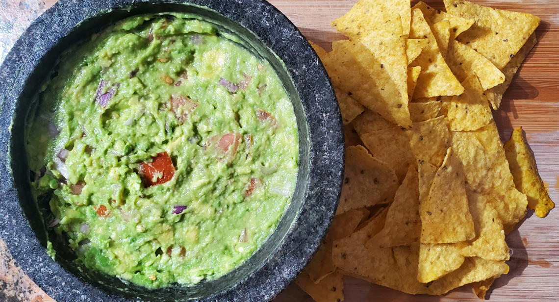 Tortilla chips next to a bowl of guacamole