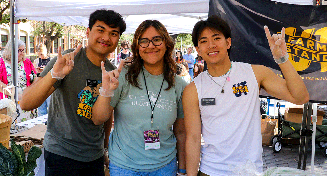 Three UT students pose together at the UT Farm Stand Market