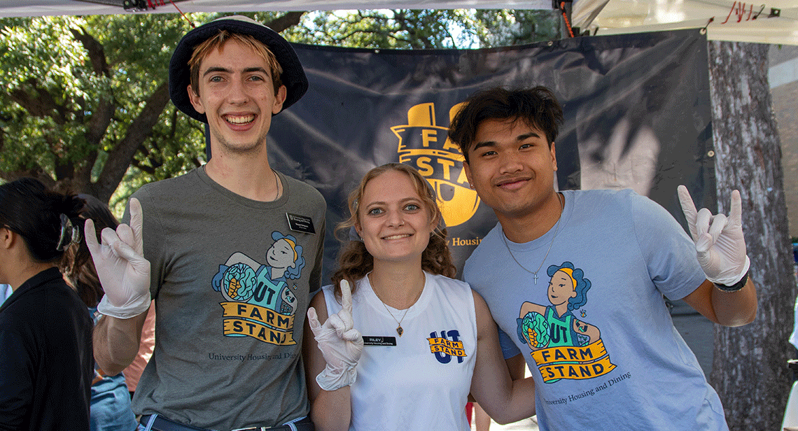 Three students pose together at the UT Farm Stand Market