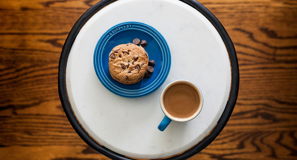 A cookie and cup of coffee on a table