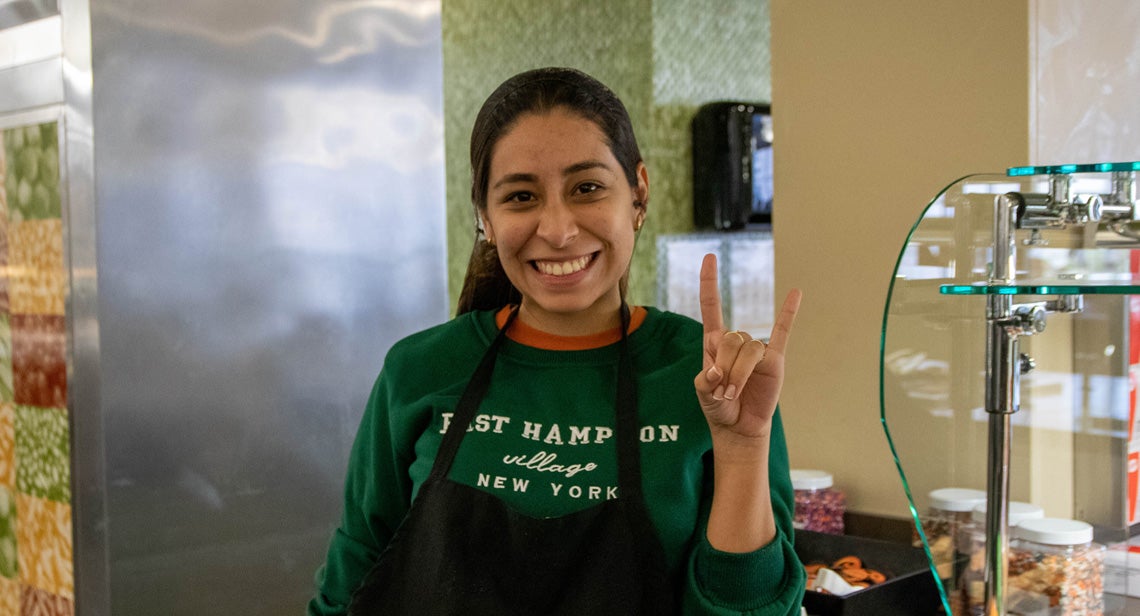 UHD staff member posing with a hook ‘em inside of J2 Dining