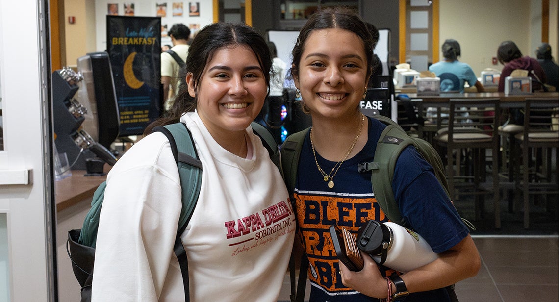 Two UT students pose together at the Late Night Breakfast event in Kins Dining