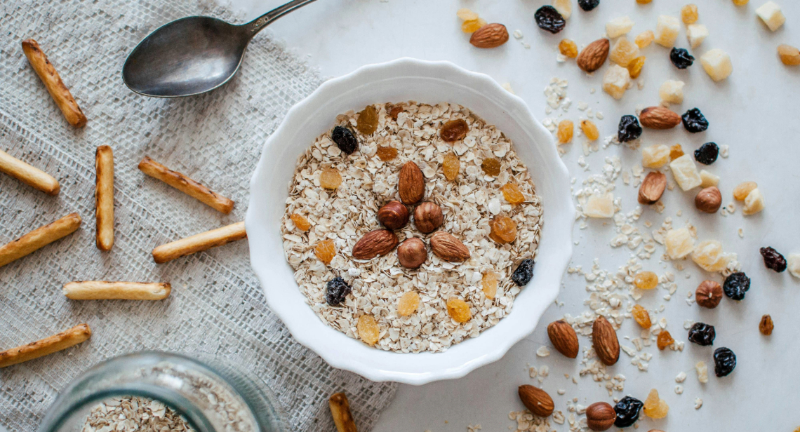 A bowl of oatmeal with nuts and dried fruit