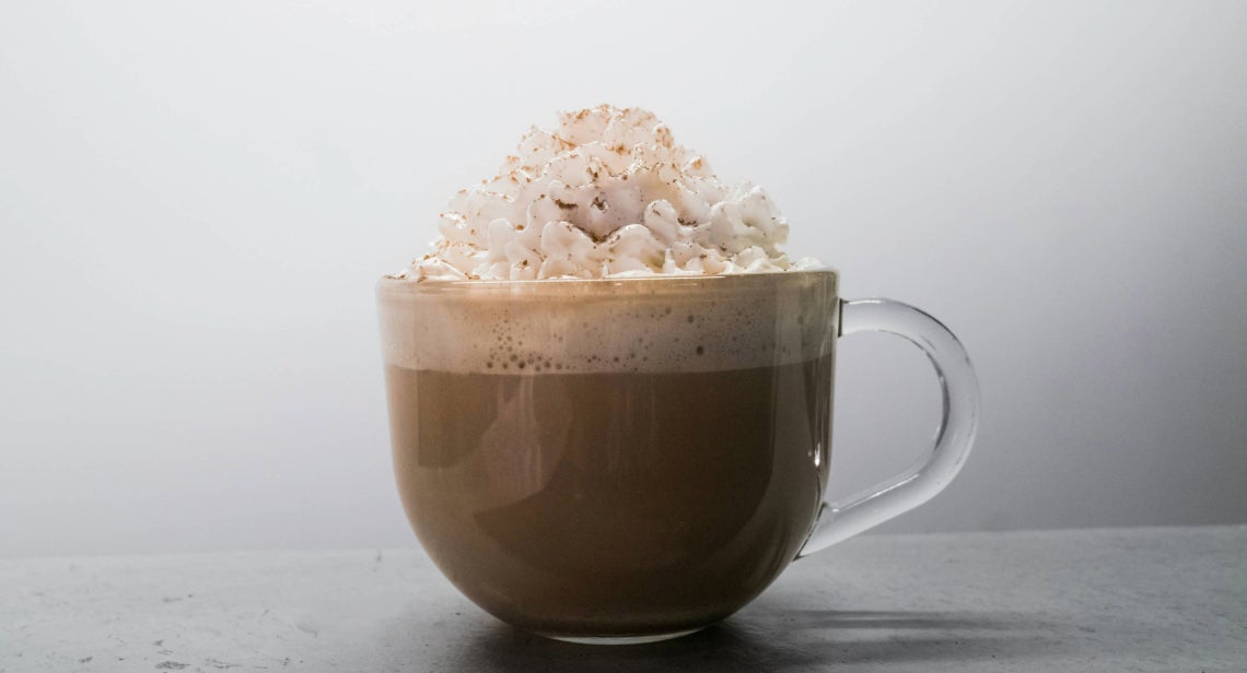 A mug of hot cocoa topped with whipped cream.