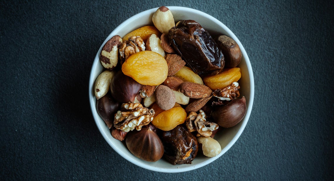 An assortment of nuts and dried fruits in a bowl. 