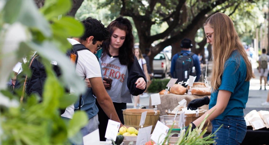 Three UT students picking local produce at UT Farm stand