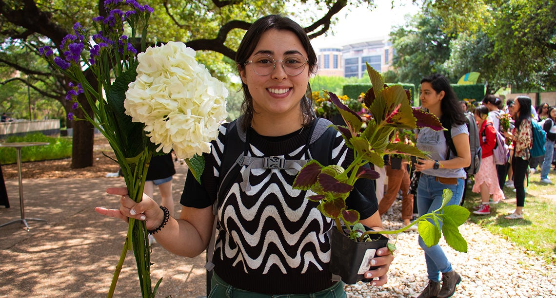 A UT student holds flowers at the Forty Acres Earth Day Fair event