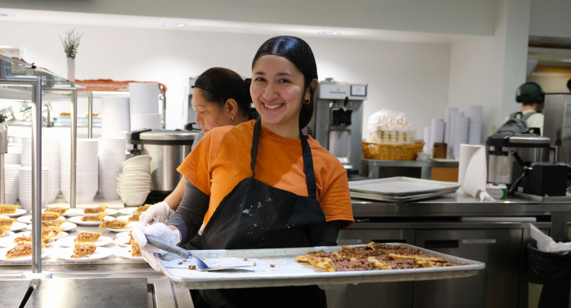 UT student dining worker holding a tray of pie slices at Kins dining hall.