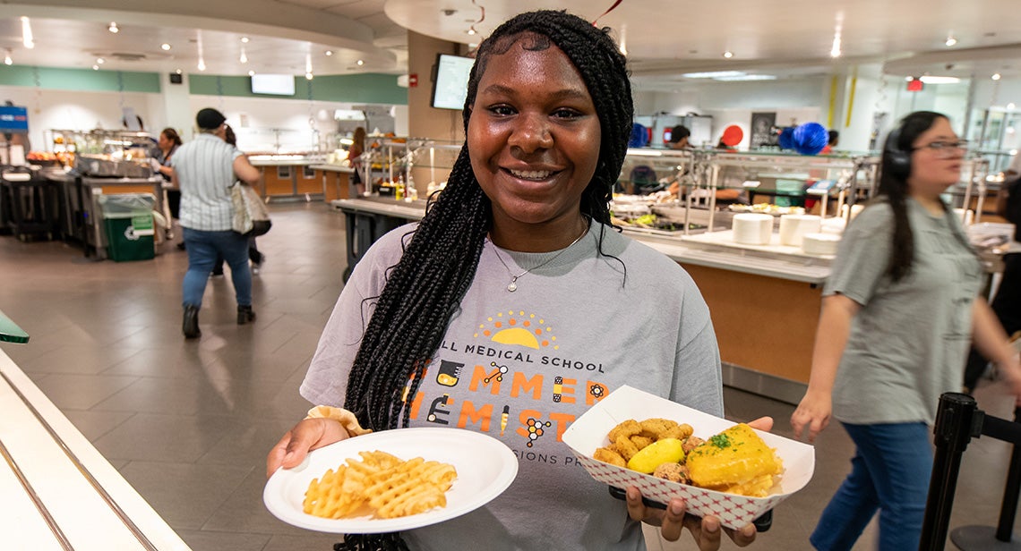 A UT student holds two plates of food in Kins Dining