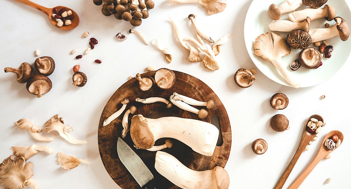 An assortment of mushrooms on a table and in plates