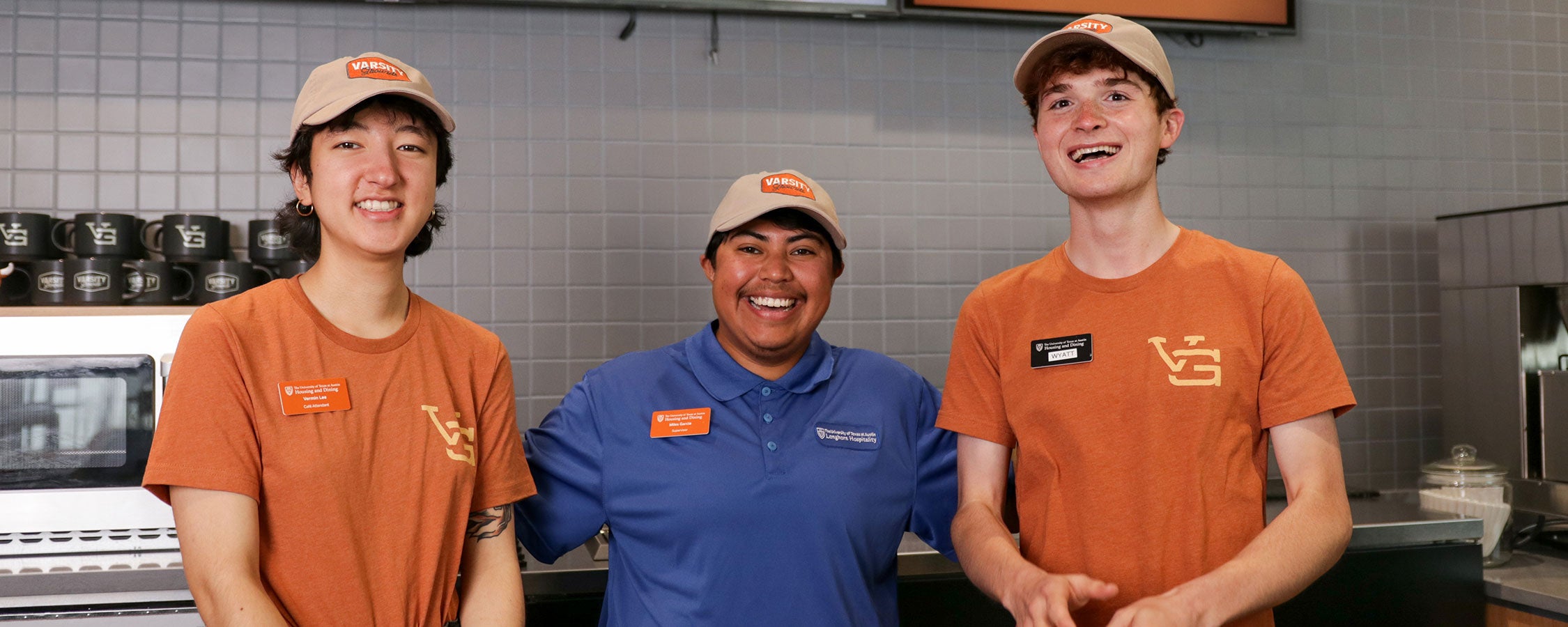Two UT student staff members and a supervisor pose together at Varsity Grounds