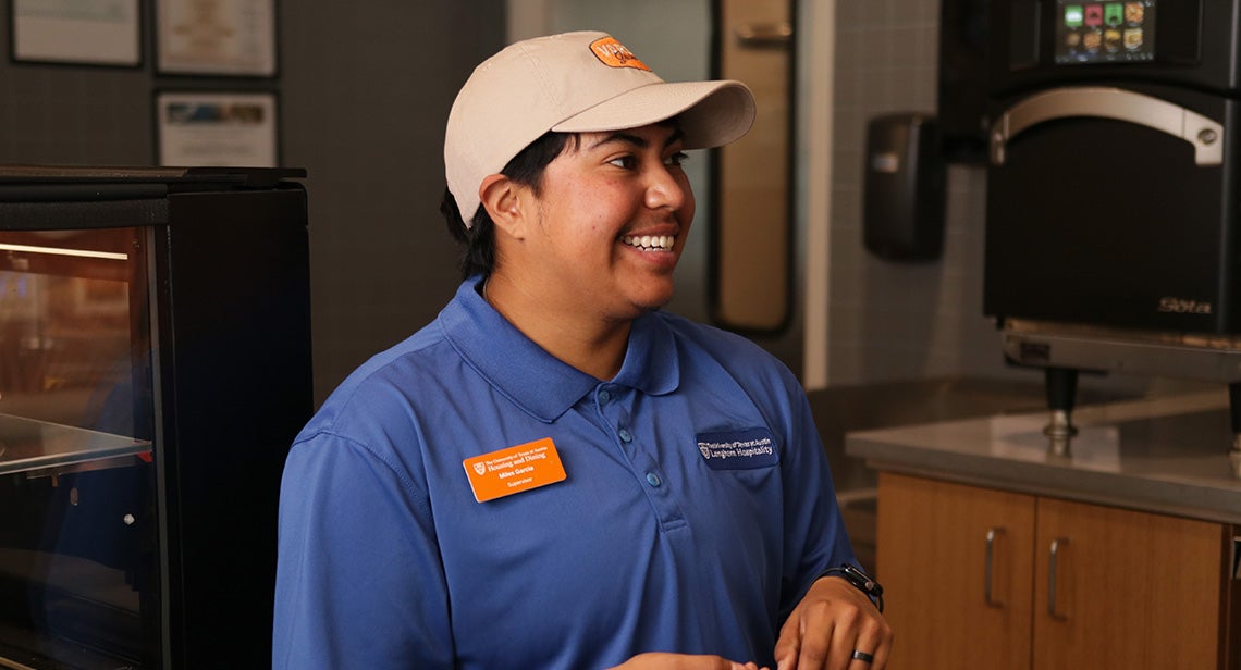 A UT student staff member poses in Varsity Grounds