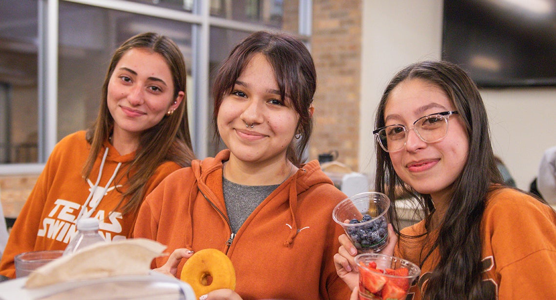 Three UT students pose together