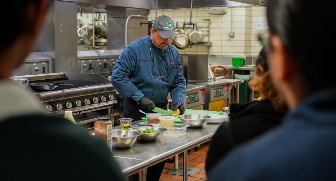 A UHD chef preparing ingredients at a Creation Kitchen event. 