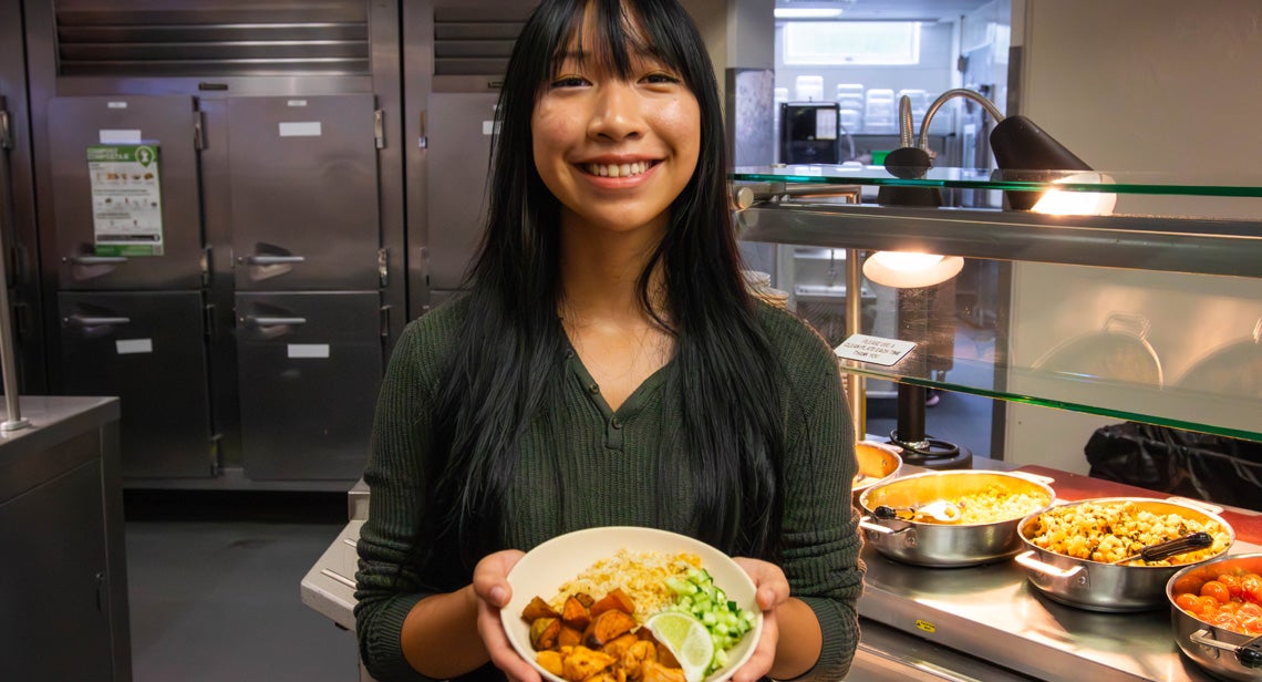 A UT student poses holding a plate of food