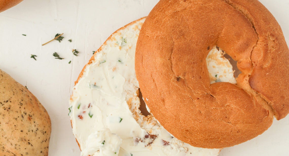 A bagel cut in half with cream cheese