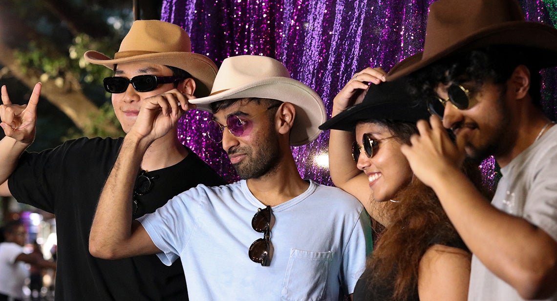 A group of UT students post together on the UT Tower steps