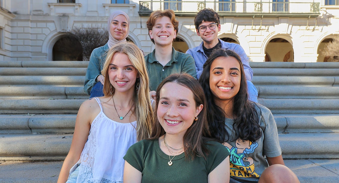 A group of UT students pose together wearing cowboy hats and sunglasses at a UHD event