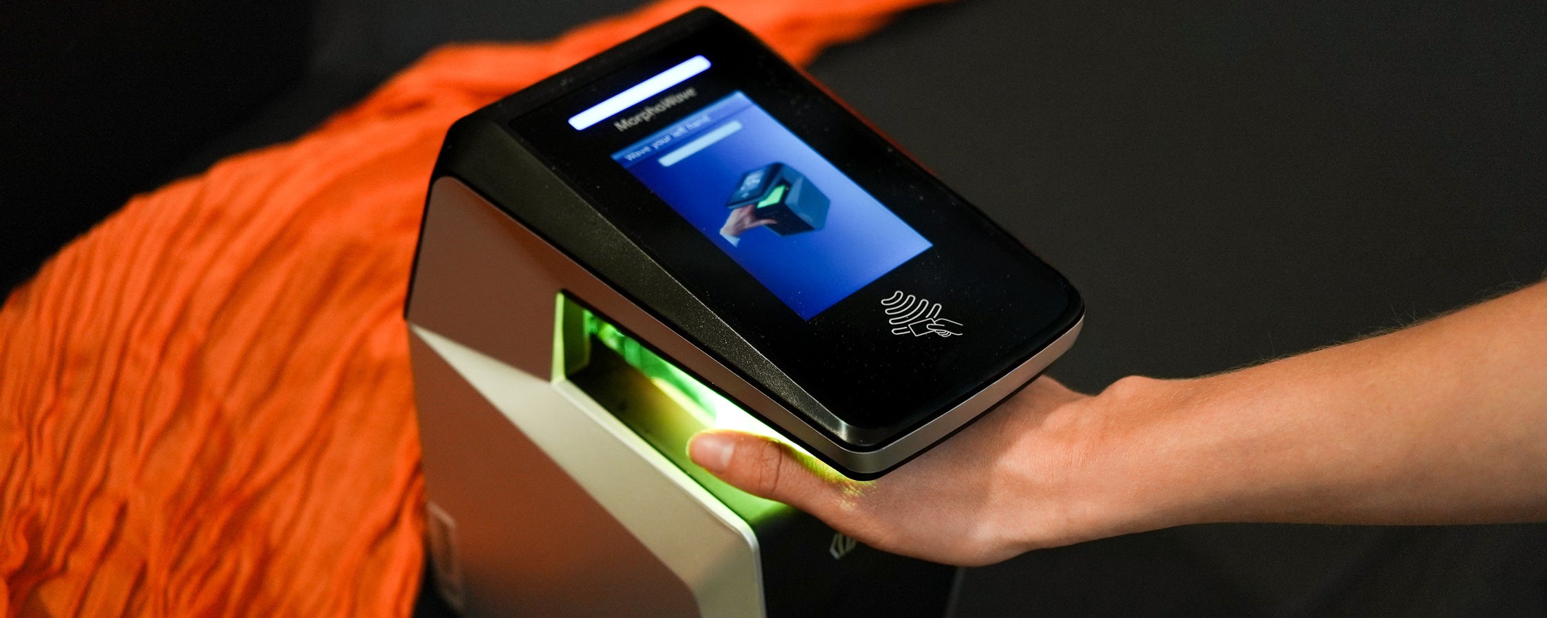 A UT student waves their hand through a hand scanner