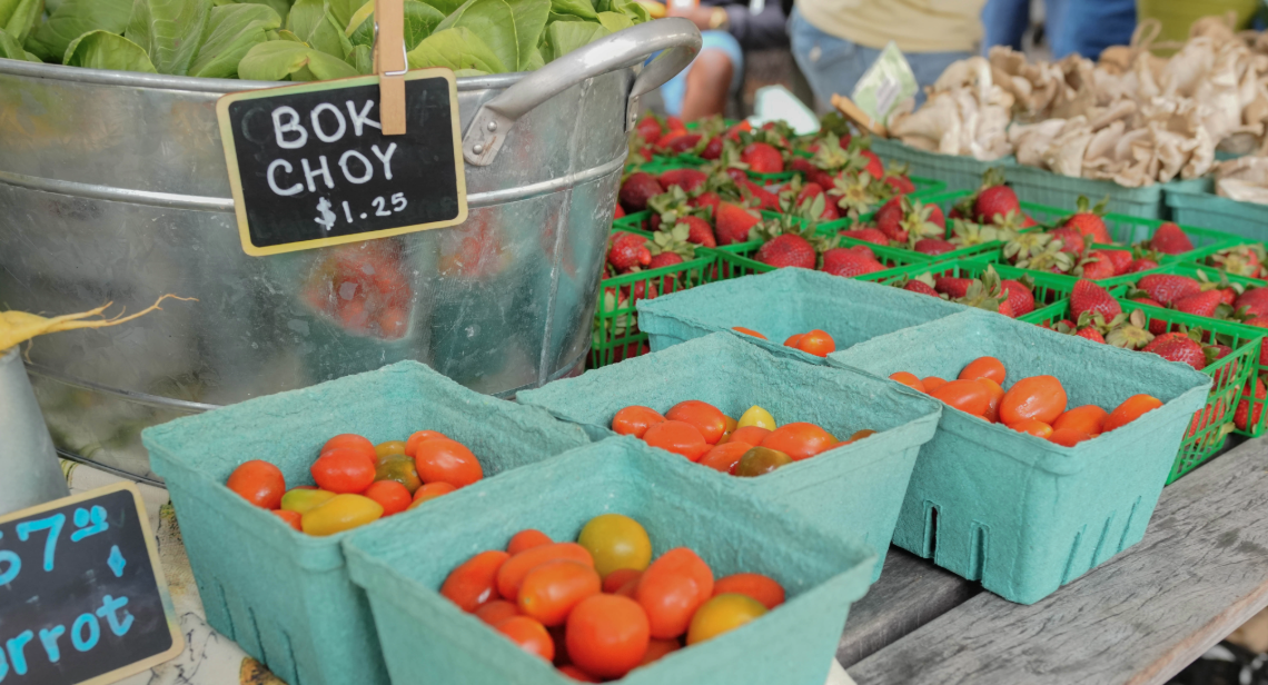 Cherry tomatoes, strawberries and bok choy on a table at a UT Farm Stand market