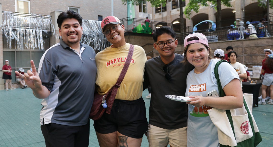 A group of UT staff members pose together at an event in  Jester Plaza