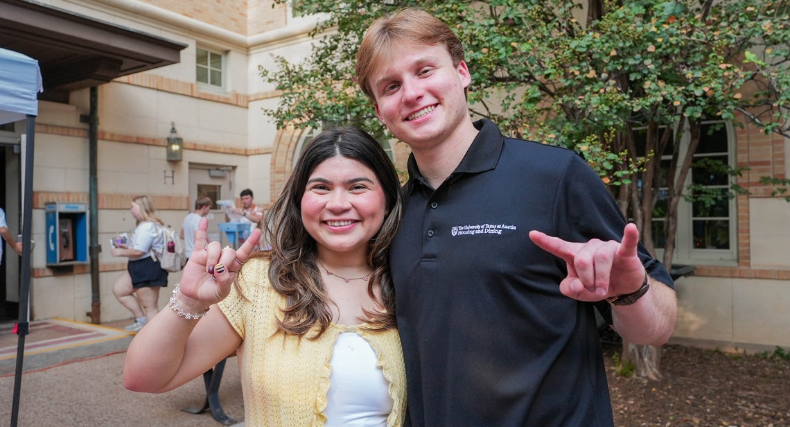 Two UT staff members pose together while making the Hook ‘em hand sign in the BRP Courtyard.