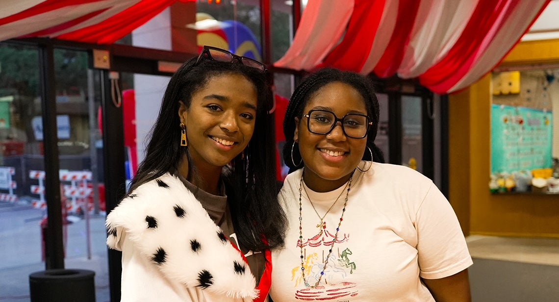 Two UT students pose together at the Kins Carnival event in Kinsolving Hall