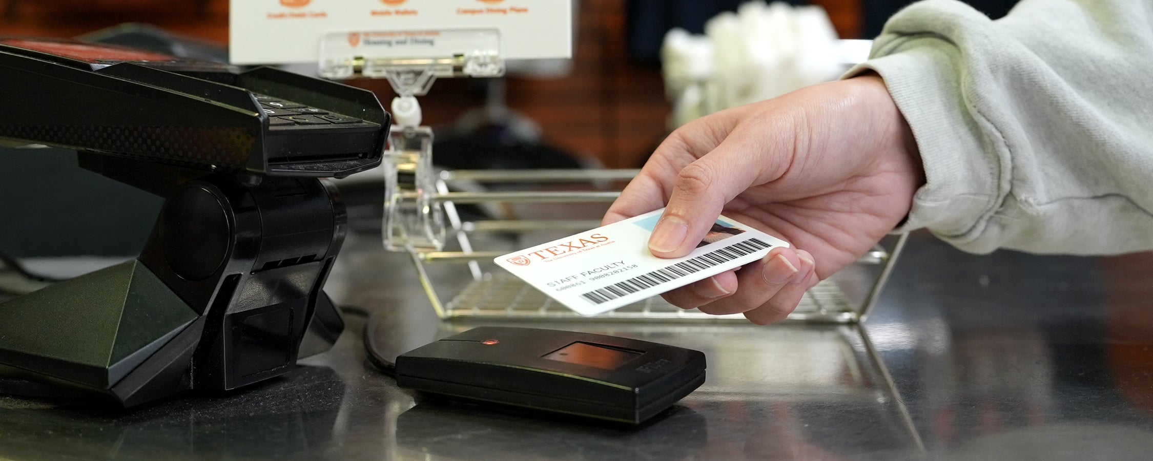 A UT staff member taps their UT ID for a purchase at Jester City Market