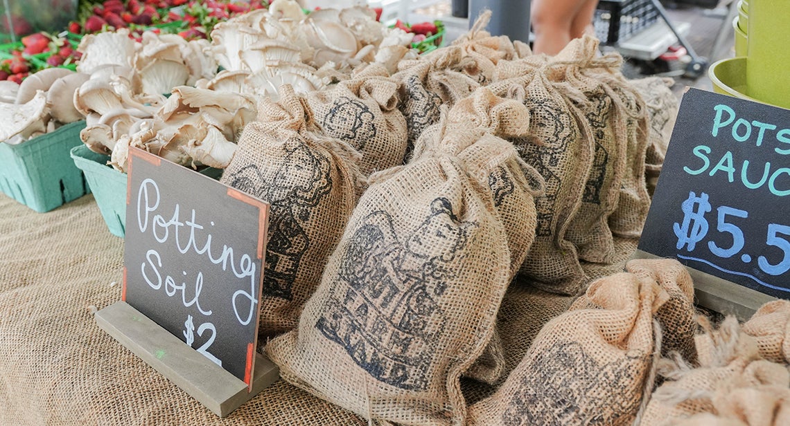 A close up of potting soil bags featuring the UT Farm Stand
