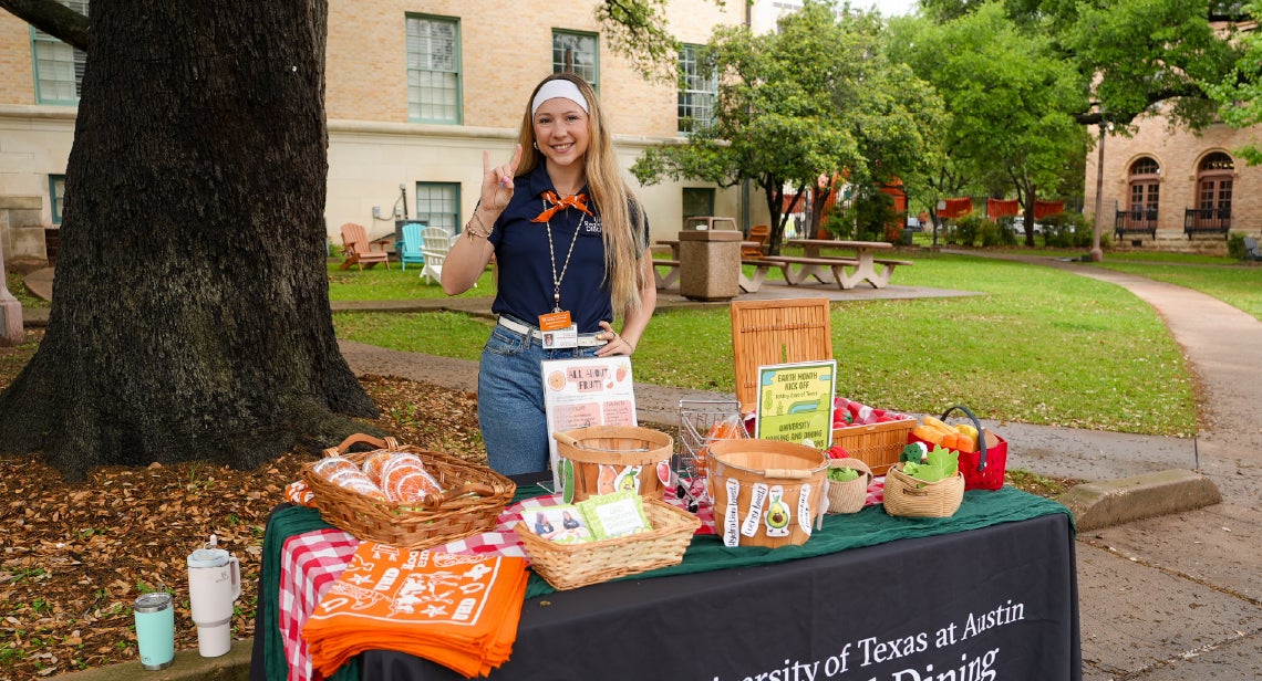 A UHD registered dietitian holding a Hook ‘em hand sign at a tabling event at the Quad courtyard. 