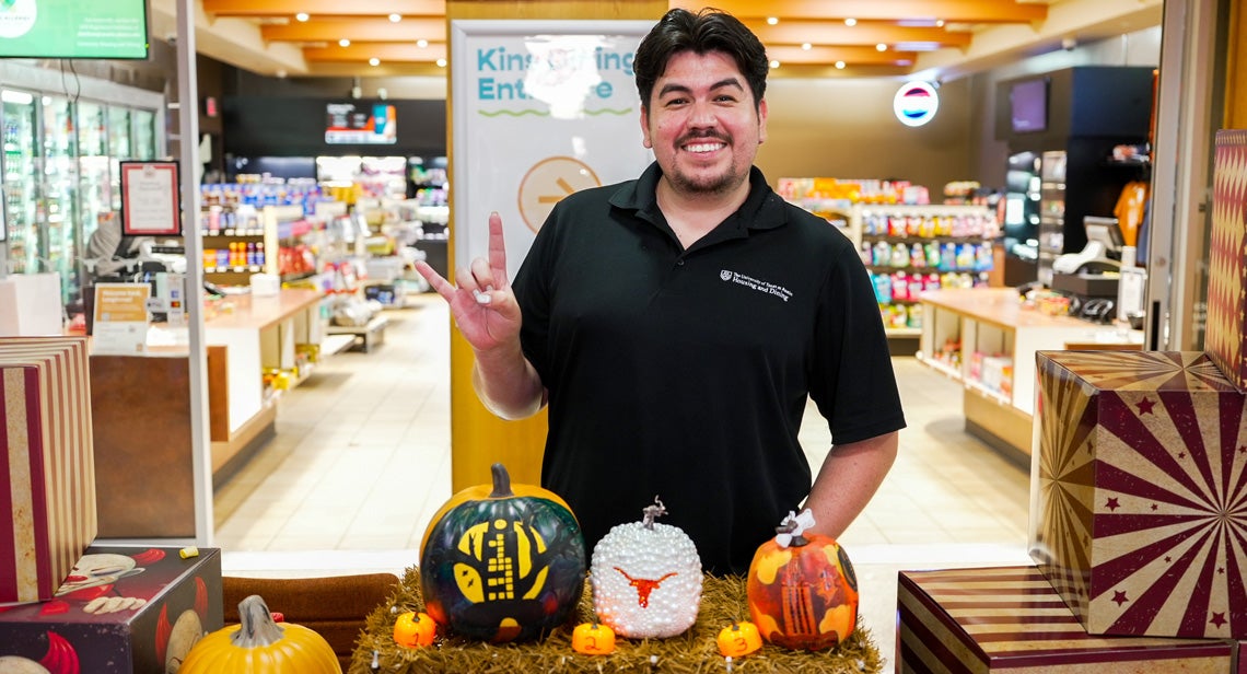 Student standing in front of pumpkins 