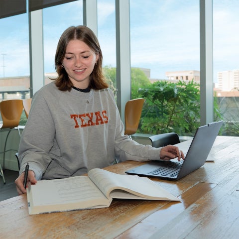 A student with a book and laptop