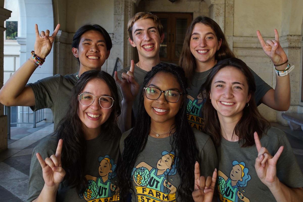 UT Farm Stand Market - six smiling staff members with horns up