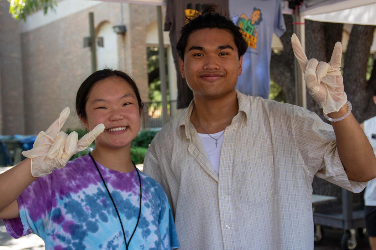 UT Farm Stand Market - two smiling students with horns up