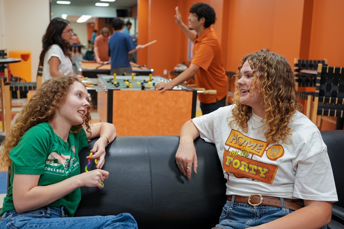 Students in Duren Two UT students wearing UT shirts converse in Duren Hall’s game lounge.