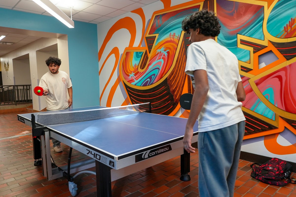 Two students play ping pong in the Jester West Fireplace Lounge.