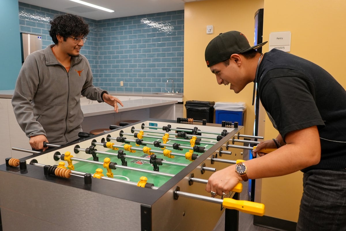 Two UT students play foosball in the Jester West Fireplace Lounge.
