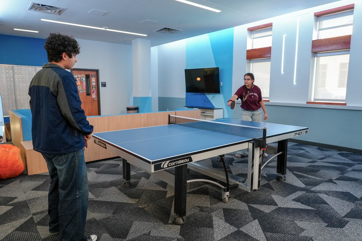Two UT students play ping pong in the Moore-Hill lounge.