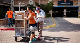 UT students pushing a baggage car