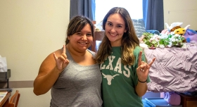 Two UT students pose together in a residence hall room during Mooov-In.