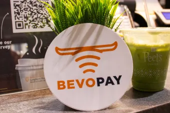 A Bevo Pay sticker and a Peet’s Coffee Iced Matcha Green Tea Latte displayed promotionally on the ordering counter at Littlefield Patio Cafe.