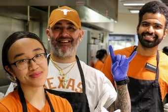 Three UHD staff members smiling in the Kins Dining kitchen