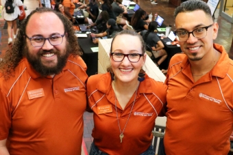 Three university and housing employees smiling at a university event.