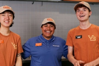 Two UT student staff members and a supervisor pose together at Varsity Grounds